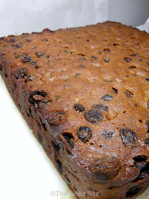 Uncut Christmas cake on baking paper after being cooked and removed from the baking tin.