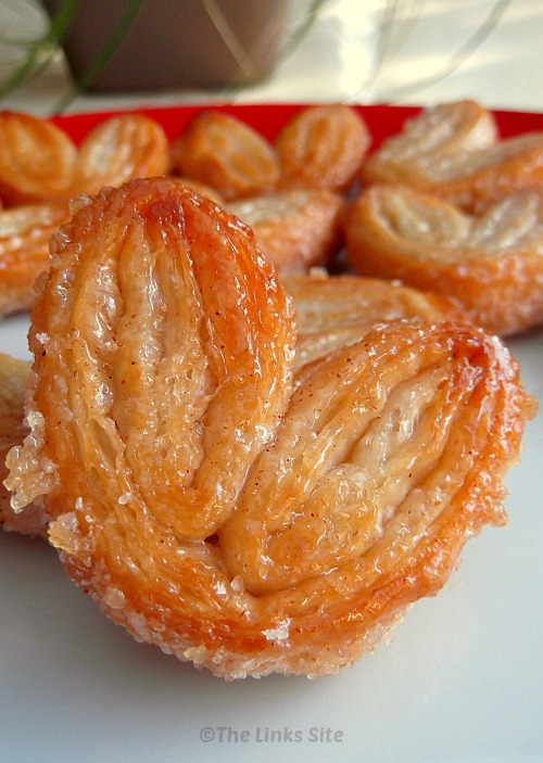 Close up of a palmier on a plate with other palmiers in the background.
