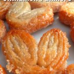 Close up of a batch of palmiers on a red and white plate with text overlay - Sweet and Crunch Cinnamon Palmiers.