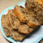 Walnut raisin loaf on a plate. Some slices have been cut from the loaf and lying on the plate.
