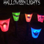 Night time image showing multi coloured lights decorated with Halloween theme pictures. Text overlay says: DIY Solar Halloween Lights (make them using regular solar garden lights!).