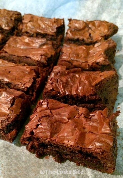 Nutella Brownie squares lined up on a piece of baking paper.