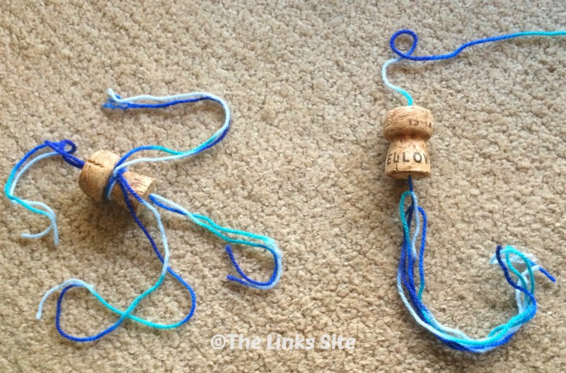 Two homemade cat toys on a carpeted floor.
