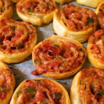 Pizza pinwheels on a baking tray.