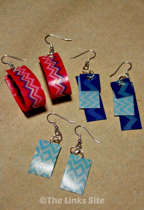 3 Pairs of earrings are pictured lying on a piece of brown craft paper.