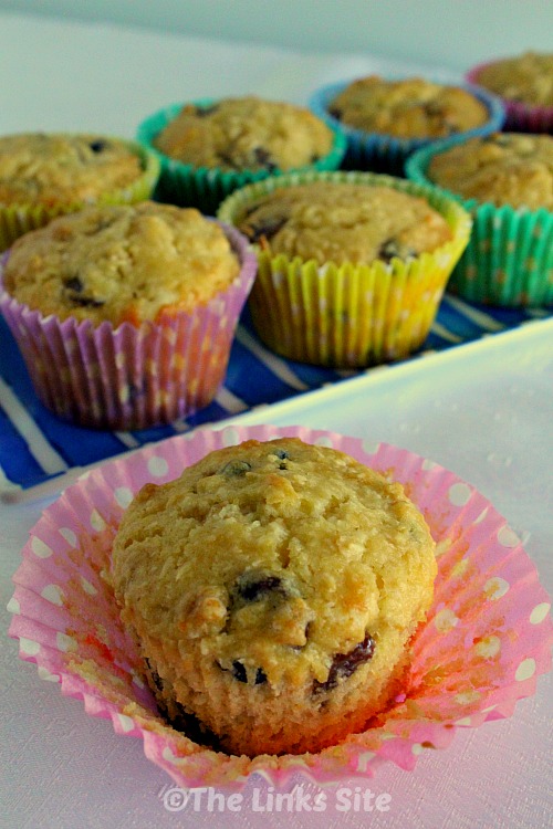 Cake mix breakfast muffin with muffin liner peeled back and other muffins in the background.