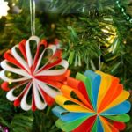 Two colourful paper decorations hanging from a Christmas tree. Text overlay says: Easy Paper Christmas Decorations.