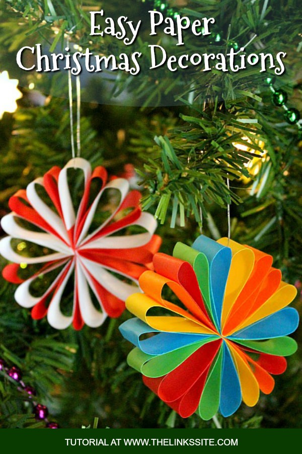 Two colourful paper decorations hanging from a Christmas tree. Text overlay says: Easy Paper Christmas Decorations.