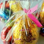 Plastic goodies bags are filled with Easter eggs of different sizes and closed at the top with a coloured twist tie. Text overlay says: Quick & Easy Easter Goodie Bags (a great last minute gift idea!).