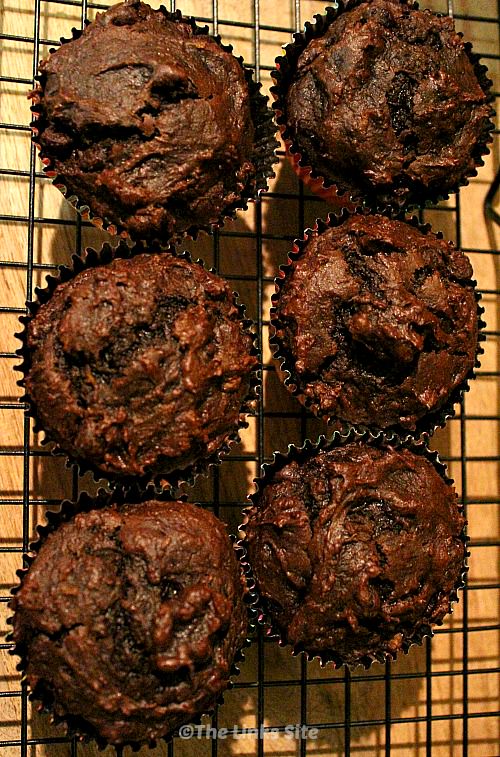 Overhead view of six muffins on a black cooling rack.