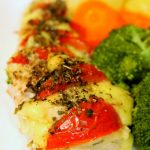 Hasselback Chicken on a white plate with vegetables.