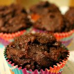 One Double Chocolate Pumpkin Muffin on a plate with more muffins in the background.