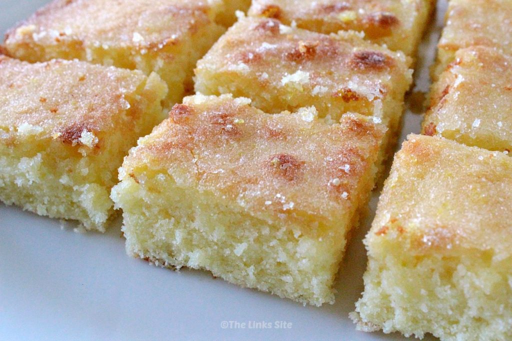 Squares of lemon cake on white plate.