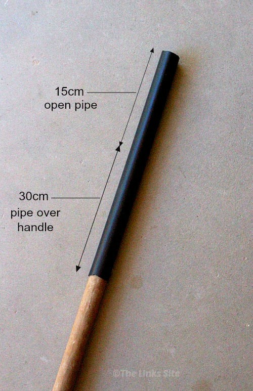 Wooden broom handle with a piece of black irrigation pipe placed over one end. Text overlay illustrates that 30cm of pipe should fit over the handle and 15cm of open pipe should be overhanging the handle. 