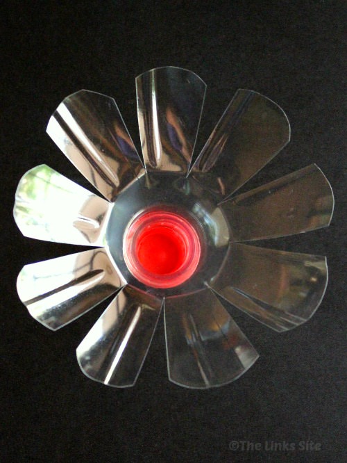 Top of a plastic soda bottle that has been cut to form a flower shape.