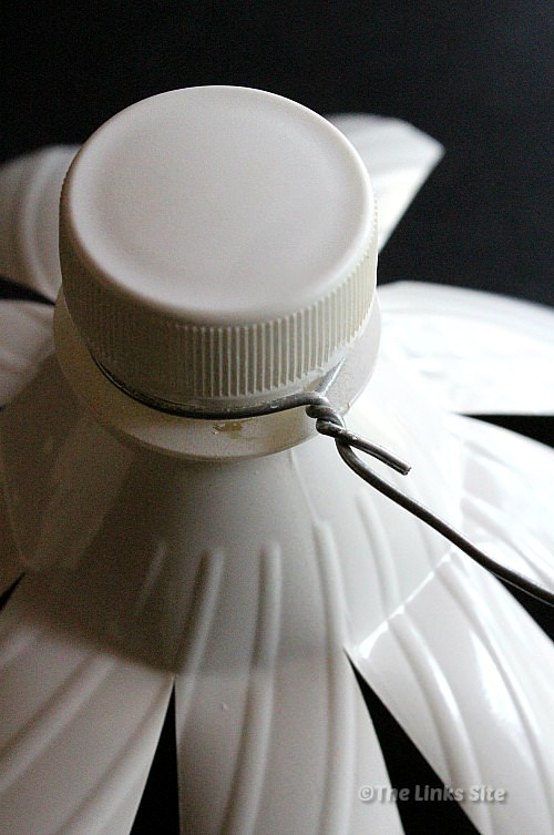 Close up of the neck of the plastic bottle showing how wire is attached.