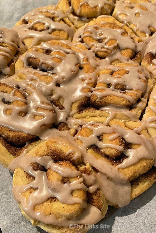 Overhead view of a batch of scrolls that have been drizzled with icing.