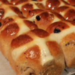 Buns are shown still joined together on baking paper and on a cooling rack.
