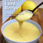 Lemon curd is dripping from a spoon into a Pale blue bowl containing more lemon curd. The bowl is on a wooden board and three lemons can be seen in the background. Text overlay says: Best Lemon Curd Recipe; No Double Boiler, No Strainer!