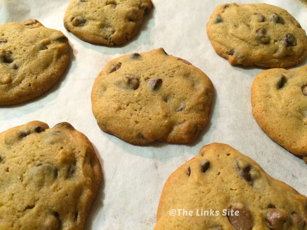 Several caramel chocolate chip cookies on baking paper.