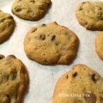 Several caramel chocolate chip cookies on baking paper.