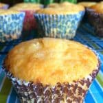 Sour Cream Lemon Muffins on a stripy tablecloth.