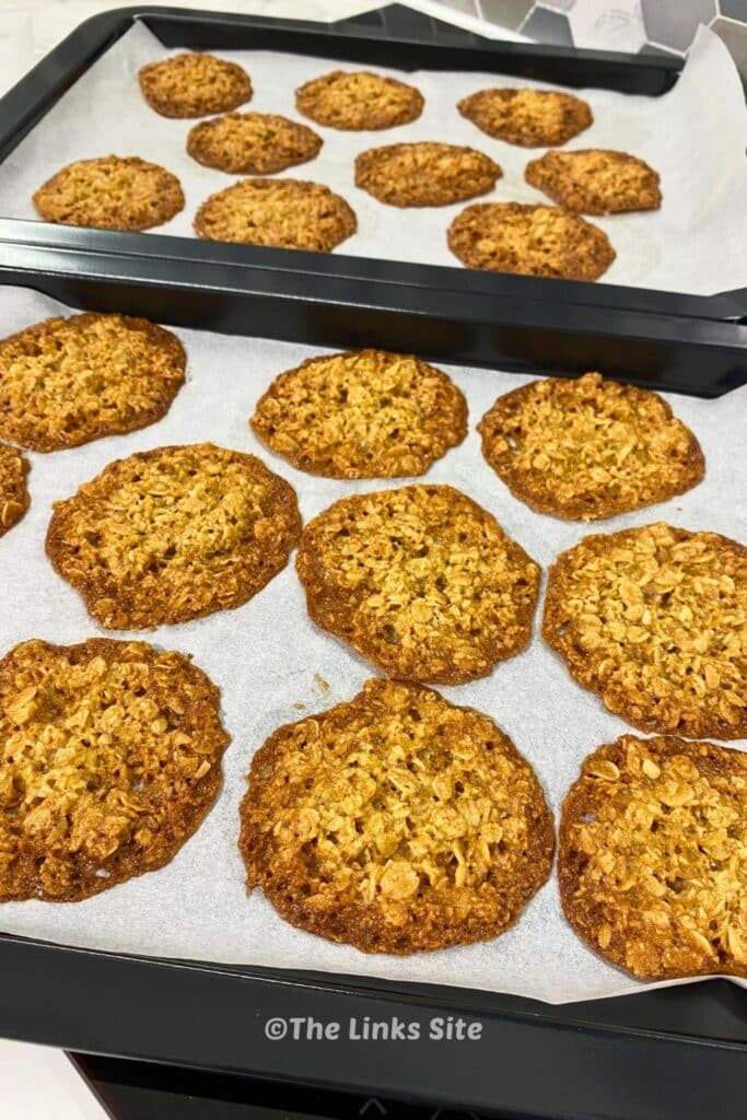 2 Baking trays of freshly baked rolled at biscuits.