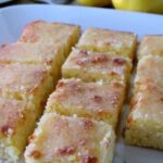 Squares of Lemon Drizzle Cake on a white plate.