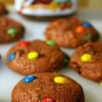 Nutella cookies with a jar of Nutella in the background.
