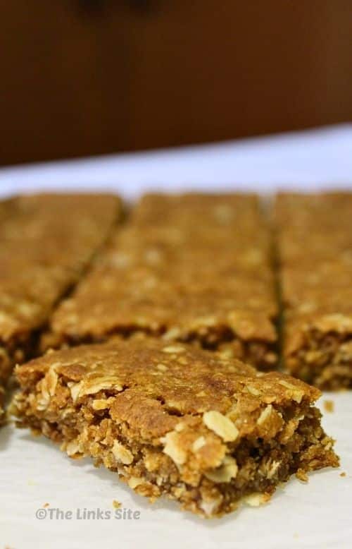 Close up of a piece of oat slice with more pieces seen in the background.