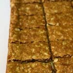 Nutty Oat Slice cut into pieces and cooling on baking paper.