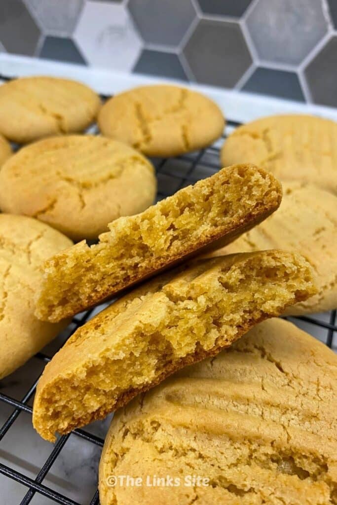 Close up of a broken golden syrup cookie showing the chewy inside texture.